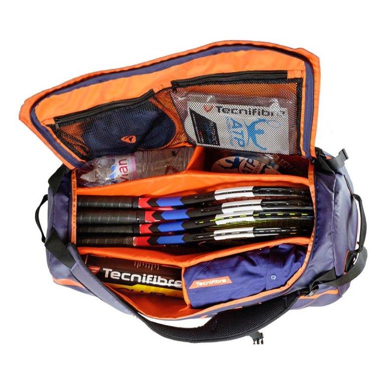 A tennis bag with 4 tennis rackets, water, balls and other suppiles.